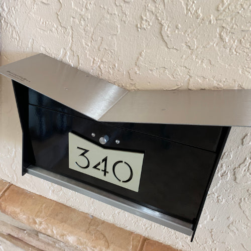 Wall Mount Mailbox mounted to outdoor wall. ButterFly Box in jet black and mid-century gold